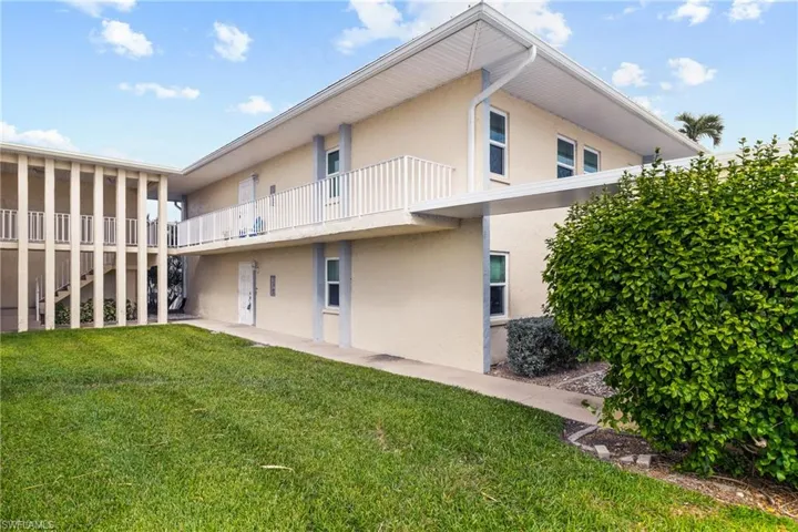 Back of property featuring a yard and a balcony