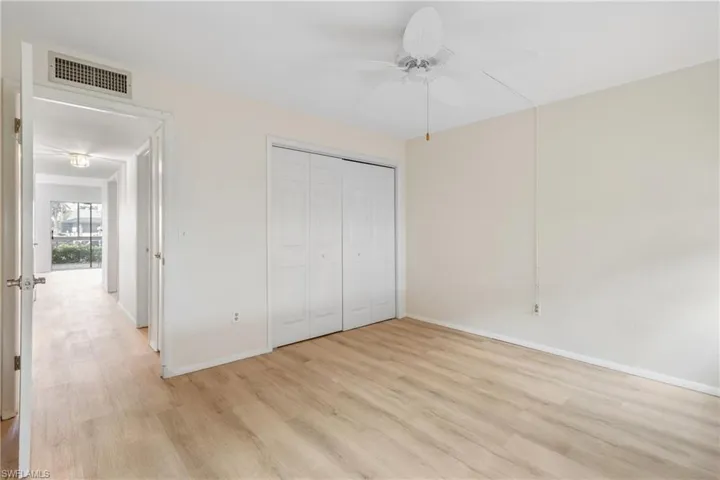 Unfurnished bedroom with ceiling fan, a closet, and light wood-type flooring