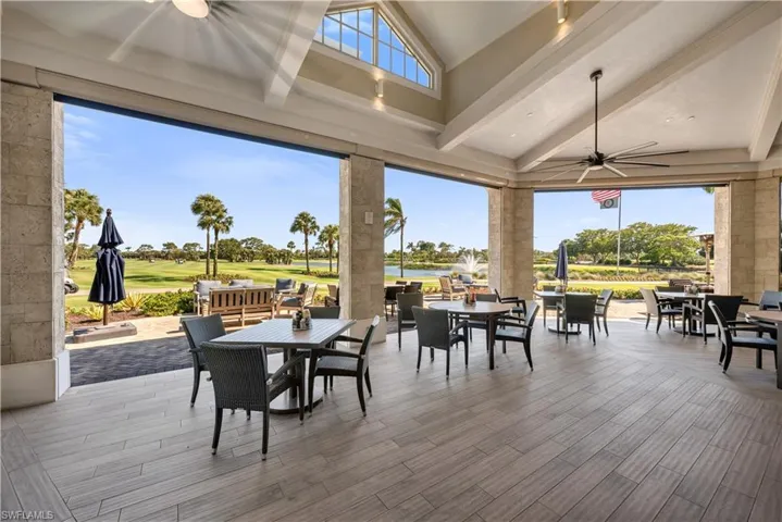 Sunroom with view of golf course, vaulted ceiling, and a water view