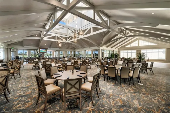 Dining area featuring dark carpet, plenty of natural light, and vaulted ceiling