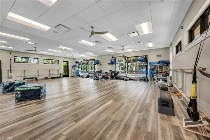 Workout area featuring a ceiling fan and a drop ceiling