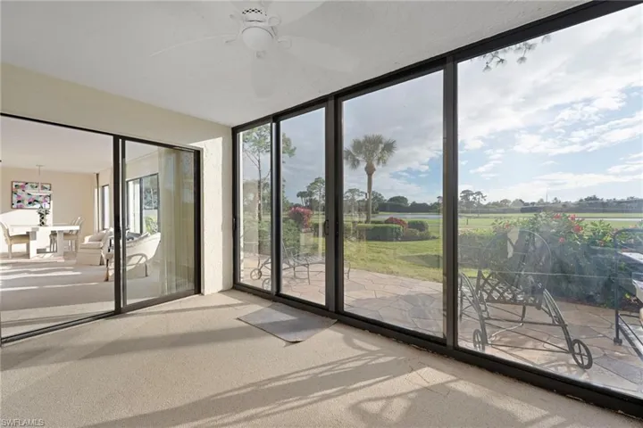 Unfurnished sunroom featuring ceiling fan and a patio