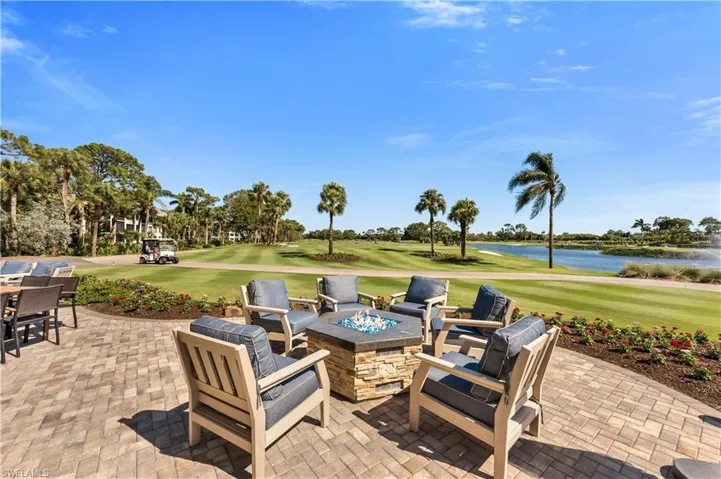 View of patio / terrace with an outdoor fire pit, view of golf course, and a water view