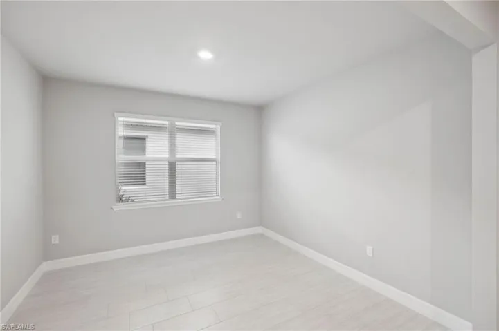 Empty room featuring baseboards and recessed lighting