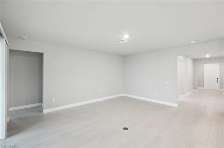 Unfurnished room with baseboards, light wood-style flooring, and recessed lighting