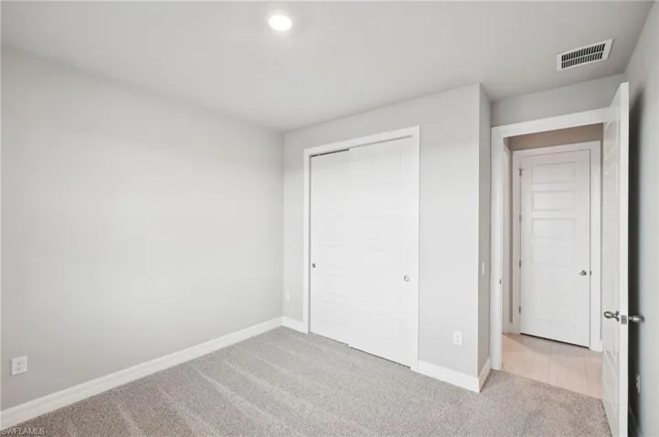 Unfurnished bedroom featuring carpet flooring, baseboards, a closet, and recessed lighting
