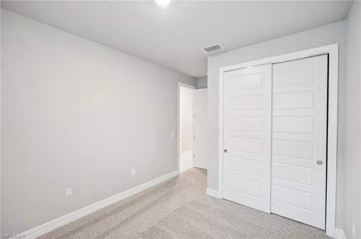 Unfurnished bedroom with carpet, baseboards, and a closet
