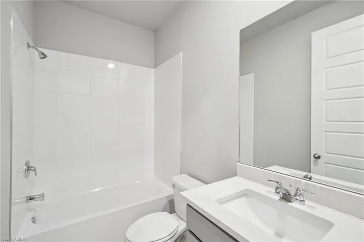 Bathroom featuring toilet, vanity, and shower / bathtub combination