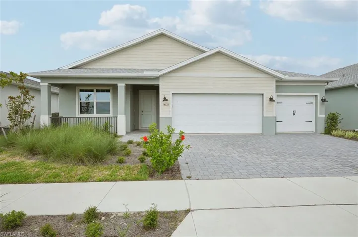 View of front of property featuring decorative driveway, covered porch, an attached garage, stucco siding, and roof with shingles