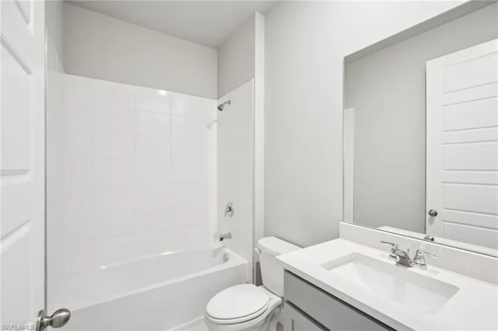 Bathroom with toilet, vanity, and bathtub / shower combination