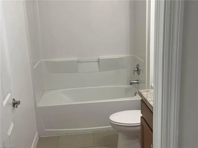 Full bathroom with light tile patterned floors and vanity