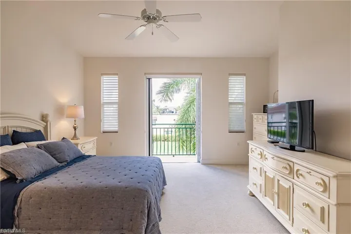 Bedroom featuring access to outside, light carpet, and a ceiling fan
