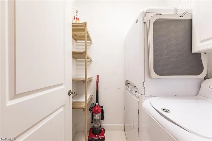 Laundry area with cabinet space and light tile patterned floors