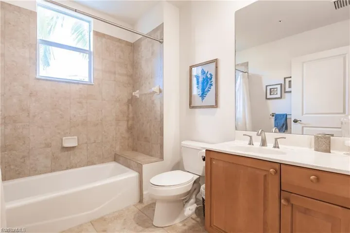 Bathroom featuring vanity, light tile patterned floors, and bathtub / shower combination
