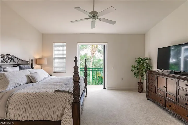 Bedroom featuring light carpet, access to exterior, and a ceiling fan