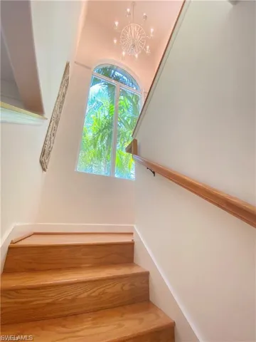 Staircase featuring a chandelier