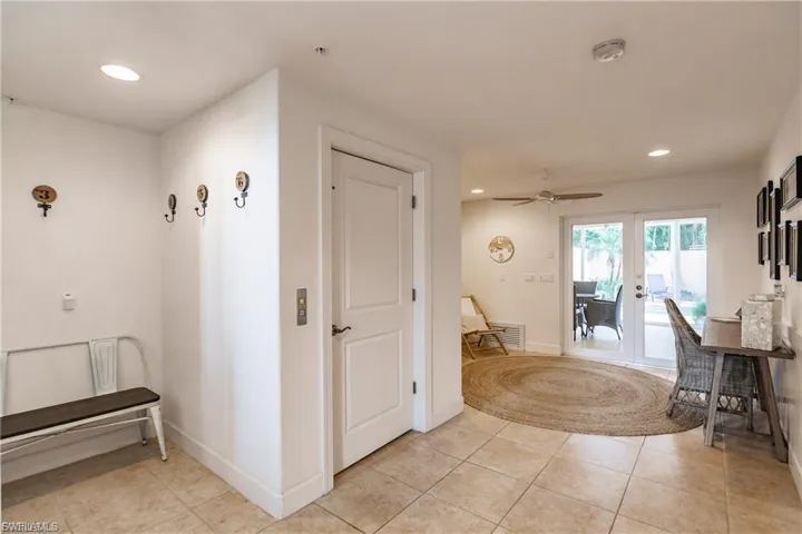 Corridor featuring recessed lighting, french doors, and light tile patterned floors