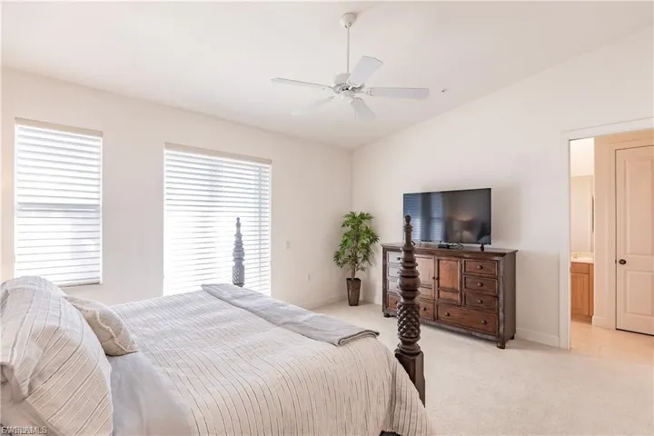 Bedroom with carpet flooring, vaulted ceiling, and a ceiling fan
