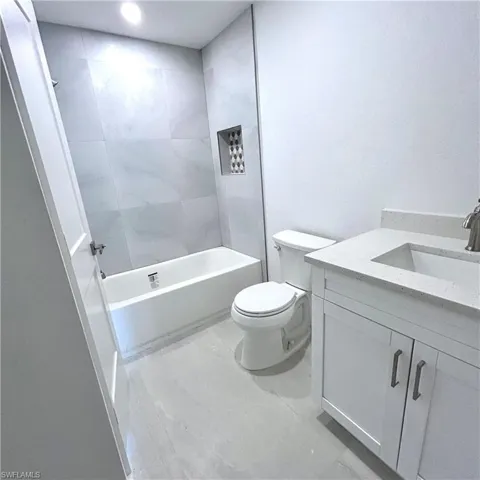 Bathroom featuring shower / bathing tub combination, toilet, and vanity