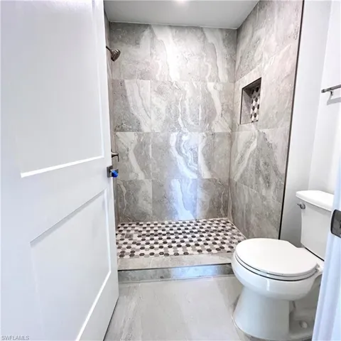 Bathroom featuring toilet and a tile shower