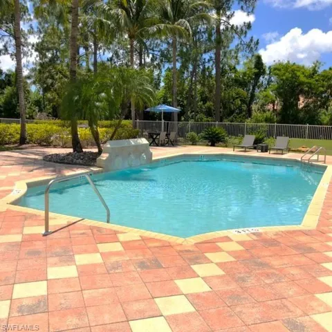 View of swimming pool featuring a patio and view of wooded area