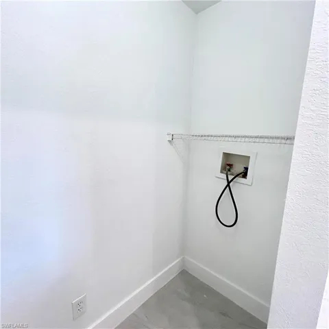 Clothes washing area featuring washer hookup, laundry area, and baseboards