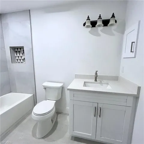 Bathroom with baseboards, toilet, and vanity