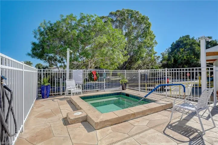 View of pool with a community hot tub and a patio