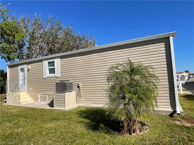 View of home's exterior featuring a yard and central AC