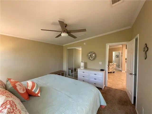 Bedroom featuring carpet floors, ceiling fan, and crown molding