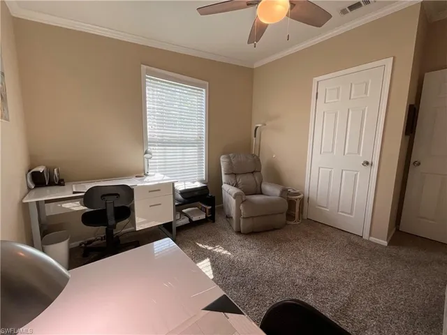 Office area featuring carpet flooring, ceiling fan, and ornamental molding