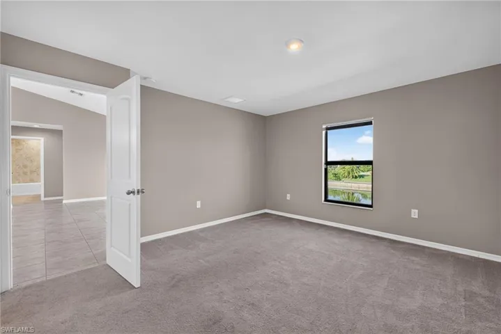 Carpeted room featuring a single window, recessed lighting, and a neutral wall color