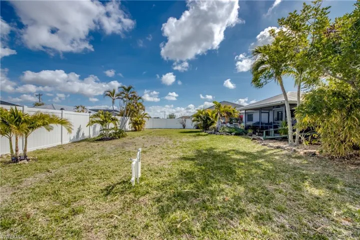 Fenced backyard featuring a sunroom