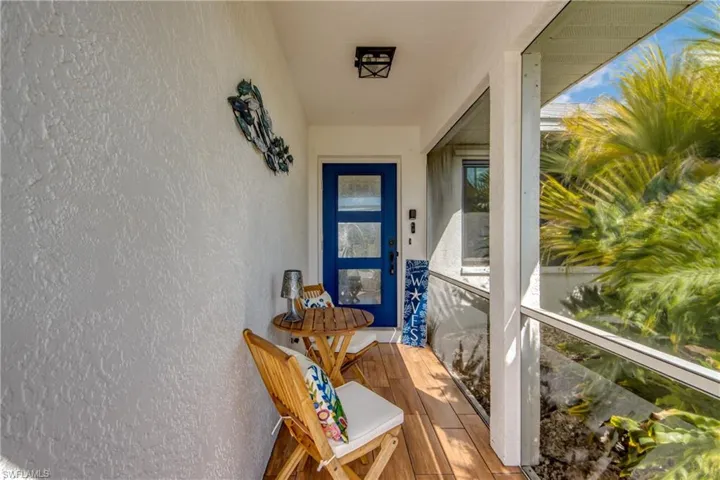 View of exterior entry with stucco siding and a sunroom