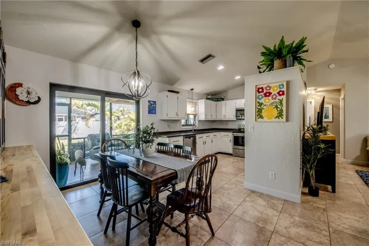 Dining space featuring lofted ceiling, suspended lighting, and light tile patterned flooring