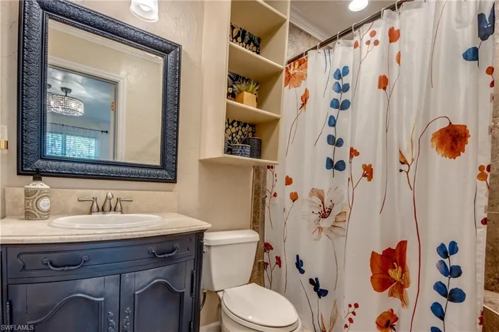 Bathroom with a shower with curtain and vanity