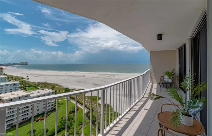 Balcony featuring a view of the beach and a water view