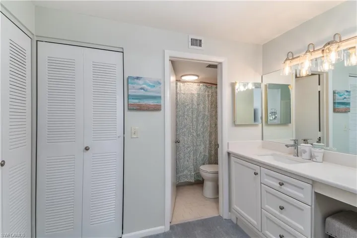Bathroom with a shower with curtain, tile patterned flooring, vanity, and toilet