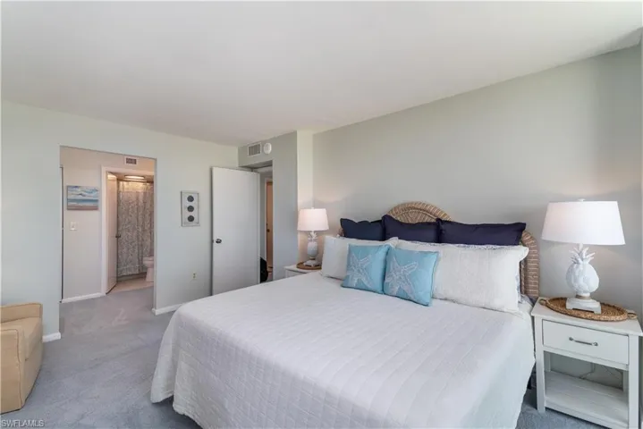 Bedroom featuring light carpet and connected bathroom