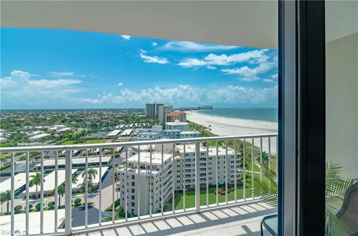 Balcony featuring a water view and a beach view