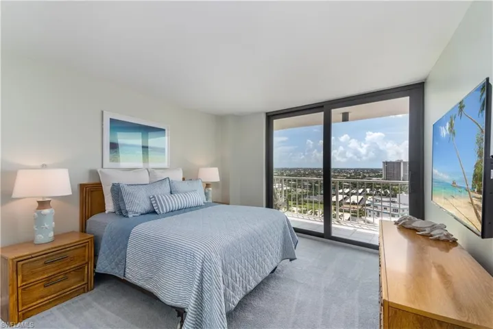 Carpeted bedroom with floor to ceiling windows and access to outside