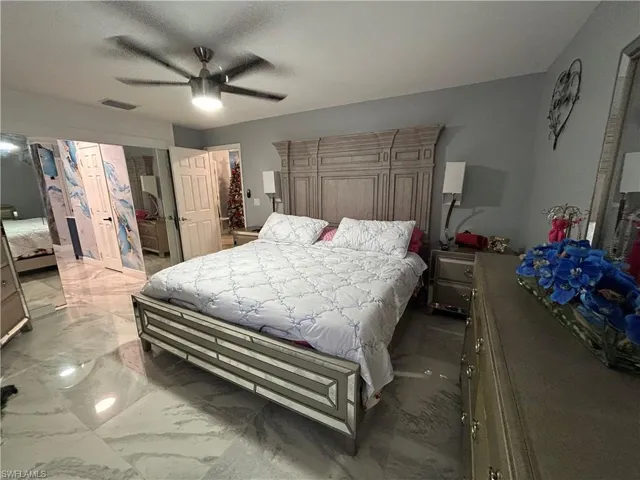 Bedroom with marble tiled flooring, a ceiling fan, and a closet