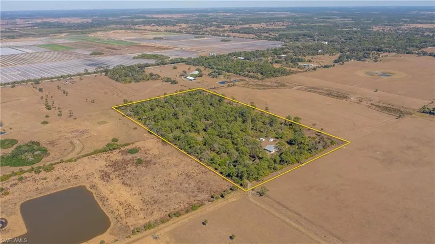 View of rural area with property parcel outlined and rows of crops
