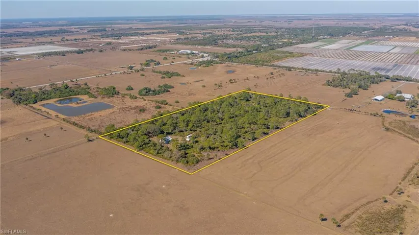 View of rural area with property parcel outlined and rows of crops