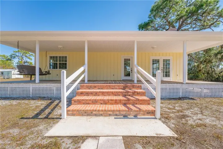 Property entrance featuring covered porch and french doors