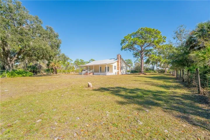 View of grassy yard featuring covered porch