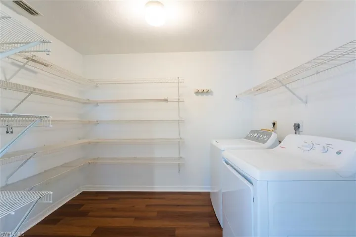 Laundry room featuring dark wood-style flooring and separate washer and dryer