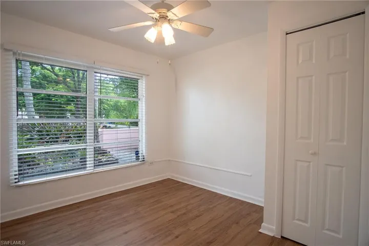 Unfurnished room with ceiling fan and dark hardwood / wood-style flooring