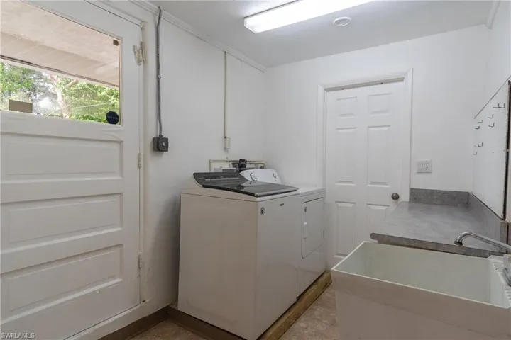 Laundry area featuring separate washer and dryer and sink