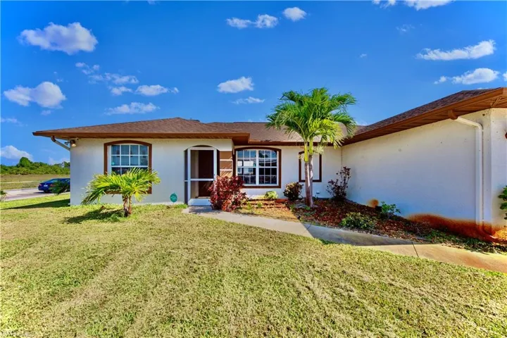 View of front of property featuring stucco siding and a front lawn